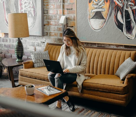 Woman sitting on a couch using her laptop