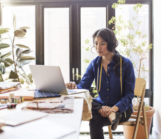 Woman sitting at desk working on her laptop.