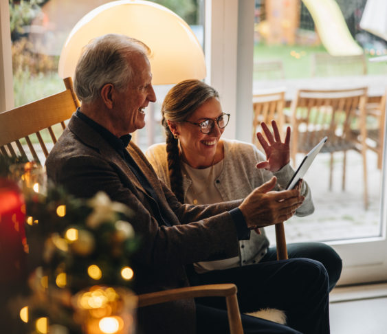 Family sitting together huddled around a tablet during Christmas