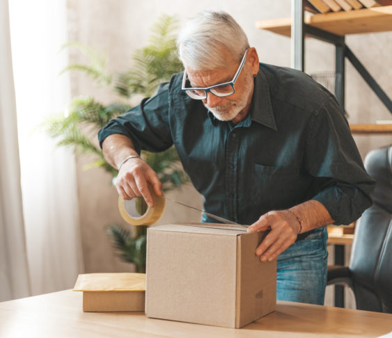 Man getting a box ready to be shipped in the mail.