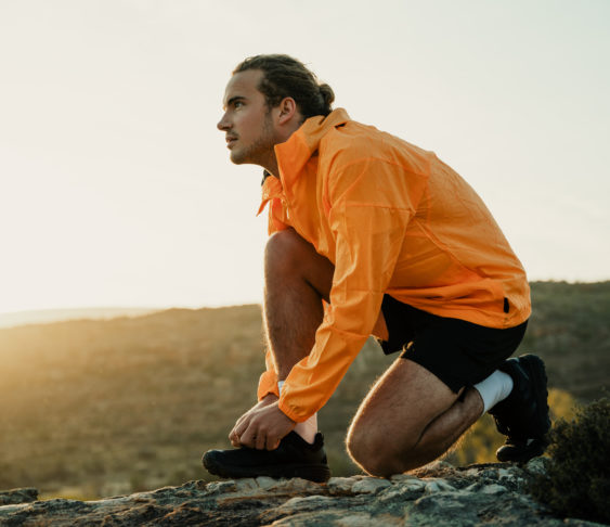 Man in workout clothes bending down to tie his shoes