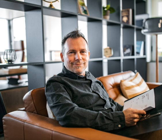 Man sitting in a chair while holding a book