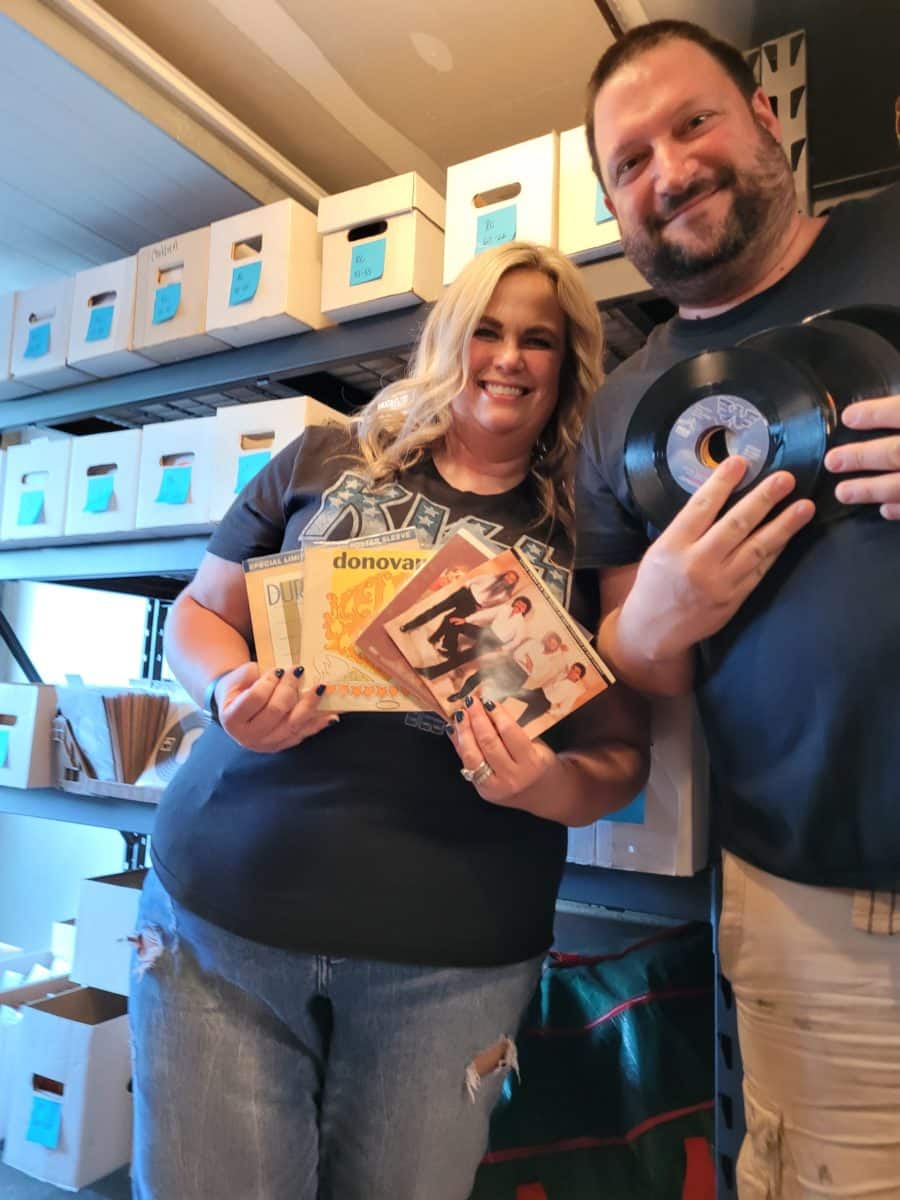 Le vendeur eBay Matt et sa femme posant avec des disques vinyles de collection à la main.