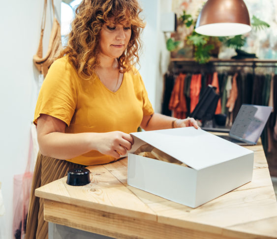 Fashion store owner preparing a package for shipment