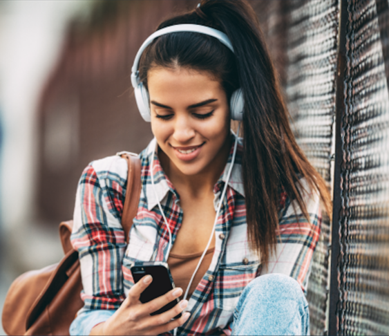 Student with headphones on her phone